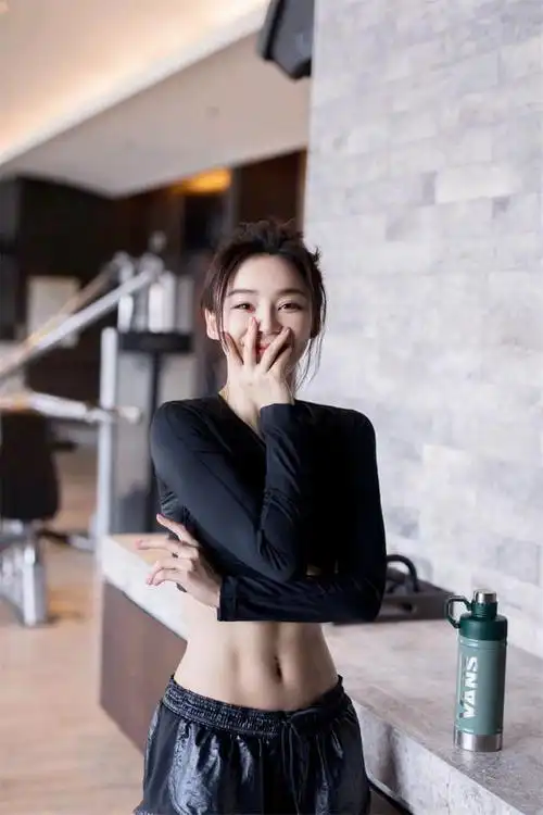 袁姗姗身穿黑色健身服,对镜甜笑,身材出众,大方展示迷人腰线