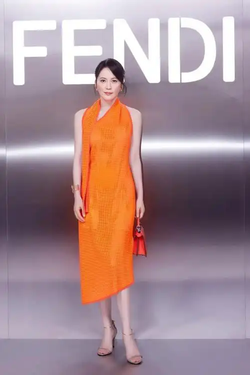 近日,俞飞鸿身穿一身亮橘色挂脖连衣裙,搭配银色高跟鞋,在巴黎参加