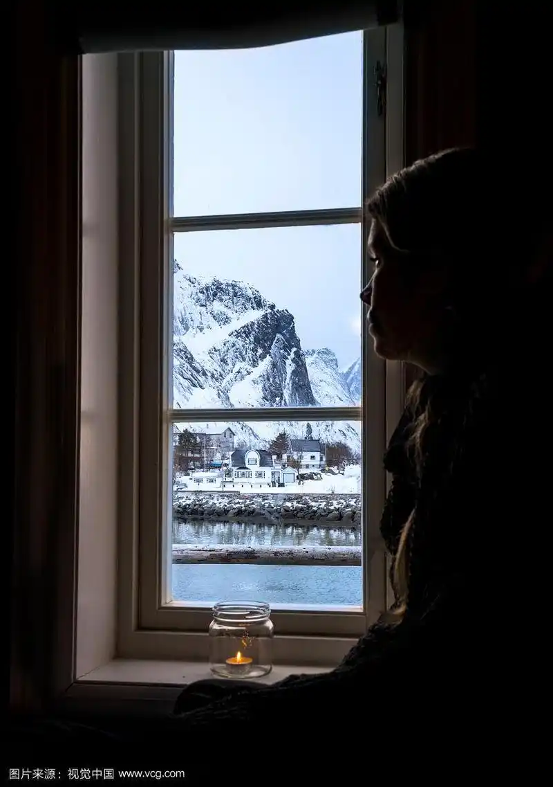 沉思的女人望着窗外的雪山,莱因,罗浮敦群岛,挪威