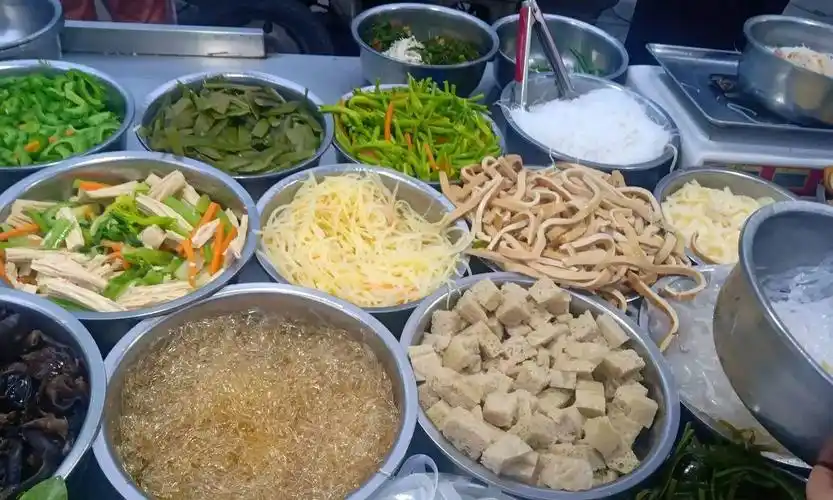 放入小盆中,顾客根据个人喜好选择几种凉菜,选好后称重再凉拌,凉拌时