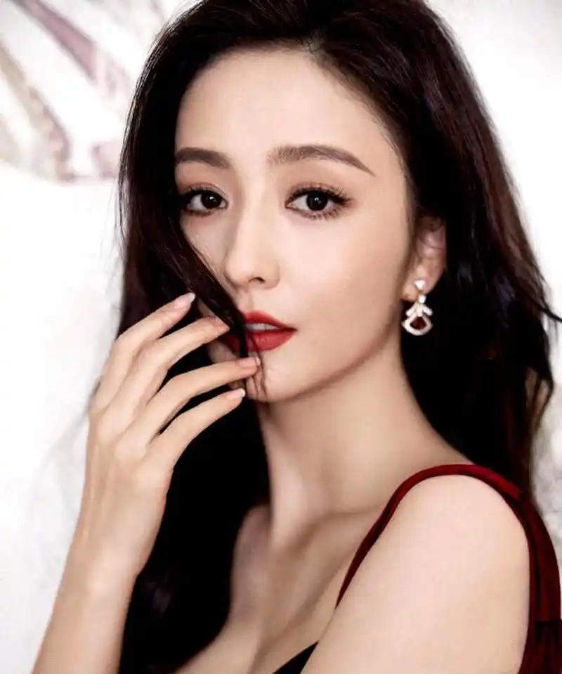 佟丽娅身穿红色吊带裙,肌肤白皙,面带明媚笑容,散发出优雅迷人的女人