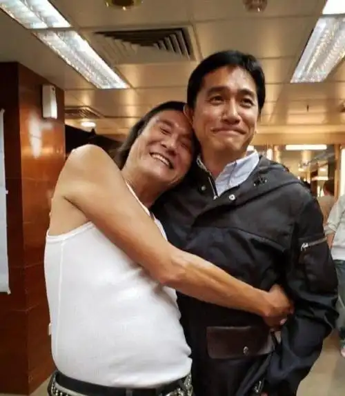 梁家辉依偎在梁朝伟的肩膀上,就像是一个孩子一样,由于身高不是非常的