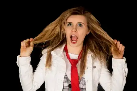 拔头发年轻女性拔头发黑色背景抓狂照片