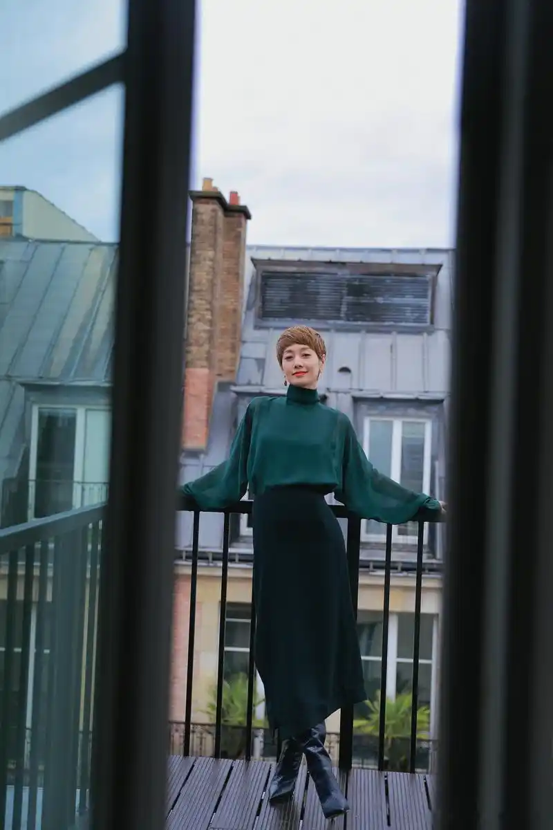 马伊琍身着松绿色真丝露背装,搭配羊毛迷笛裙及黑色长靴出席akris春夏