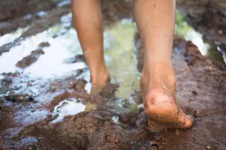 赤脚穿过泥泞的道路照片