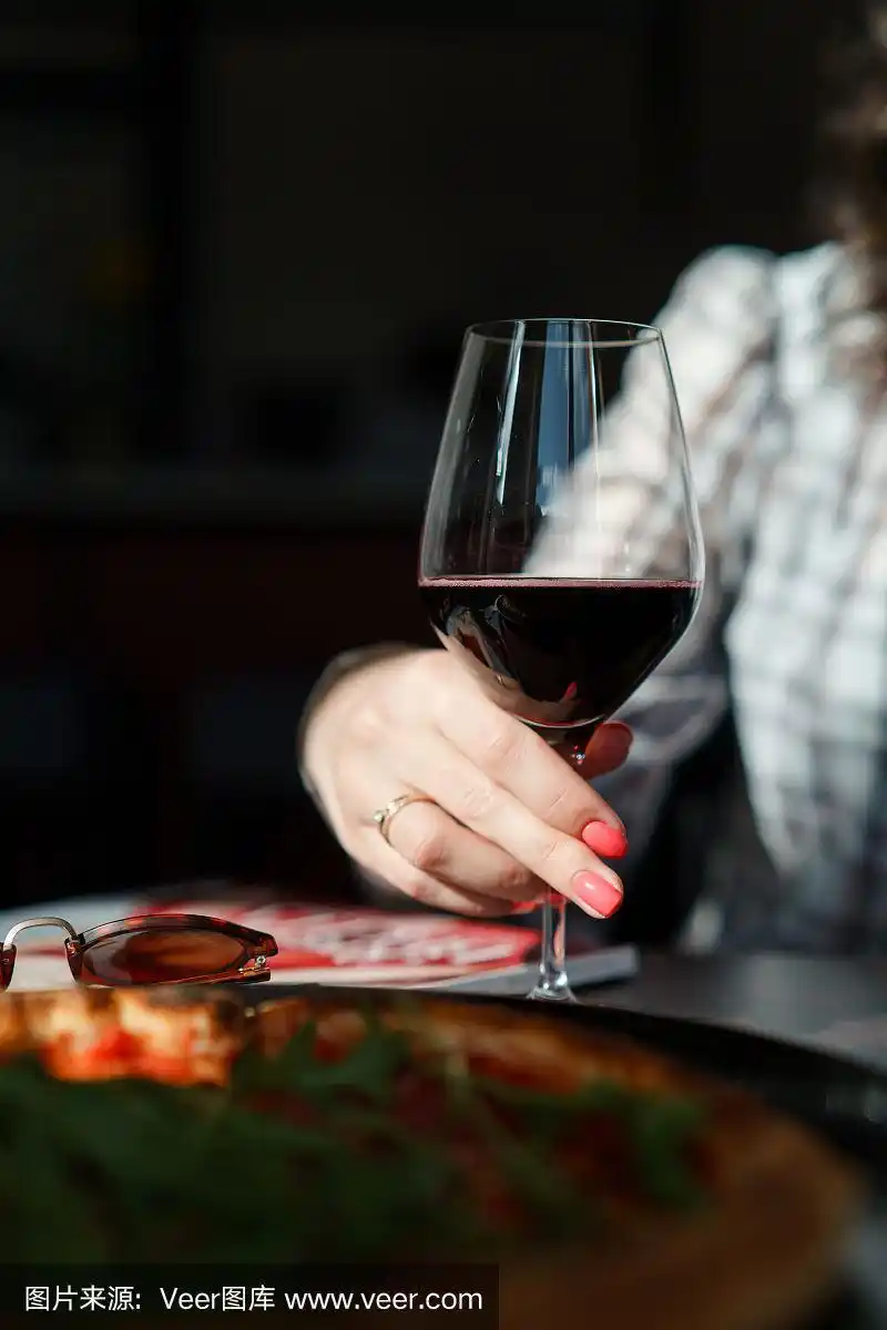 女性手握酒杯与酒的静物镜头