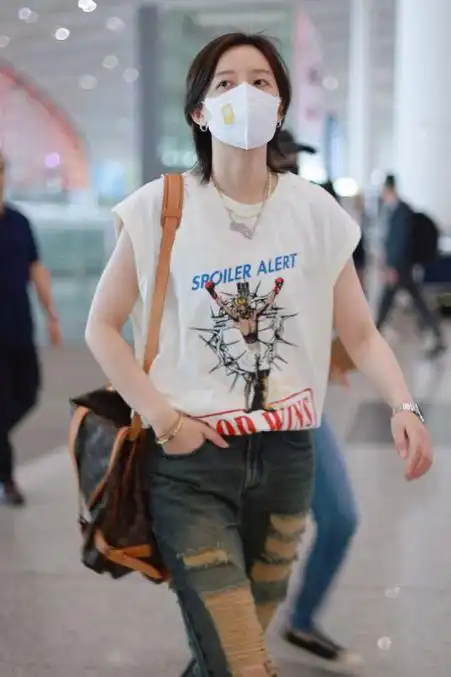 李斯丹妮脚踩复古风运动鞋,还留着漂亮的短发,背着奢华的包包,很有