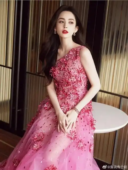 古力娜扎#惊艳礼服造型,穿着一套玫红斜肩花饰长裙,将身体与肤色障种