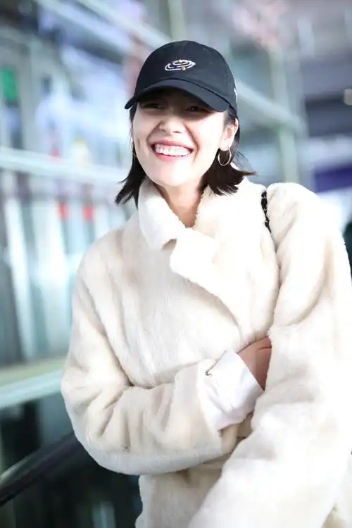 刘雯素颜搭机皮肤水嫩裹紧大衣甜笑挥手