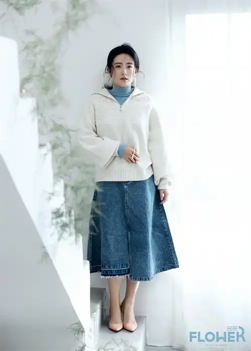 徐百慧身穿卡其色上衣搭配白色半身裙,脚踏银色高跟鞋,慵懒而不失优雅