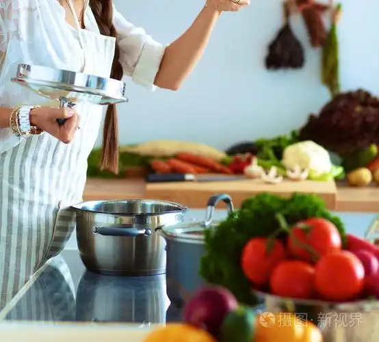 烹饪的女人在厨房里用木勺