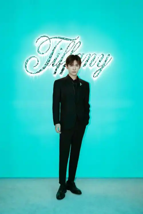 易烊千玺亮相品牌活动身着纯黑西装并造型点缀钻石鸟的胸针