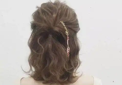 给耳朵外围的头发梳了厚实整齐的发卷,中长发做半扎发发型比较温柔,半