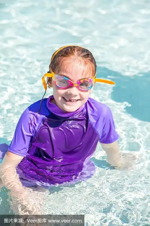 室外游泳池里的小女孩对着镜头微笑
