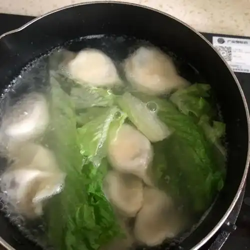第3步,捞出菜叶后,再次放入另外的菜叶煮开,如此三次,可以让饺子从内
