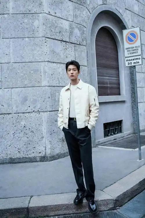 照片中肖战身穿米色夹克搭配黑色裤子时尚又复古