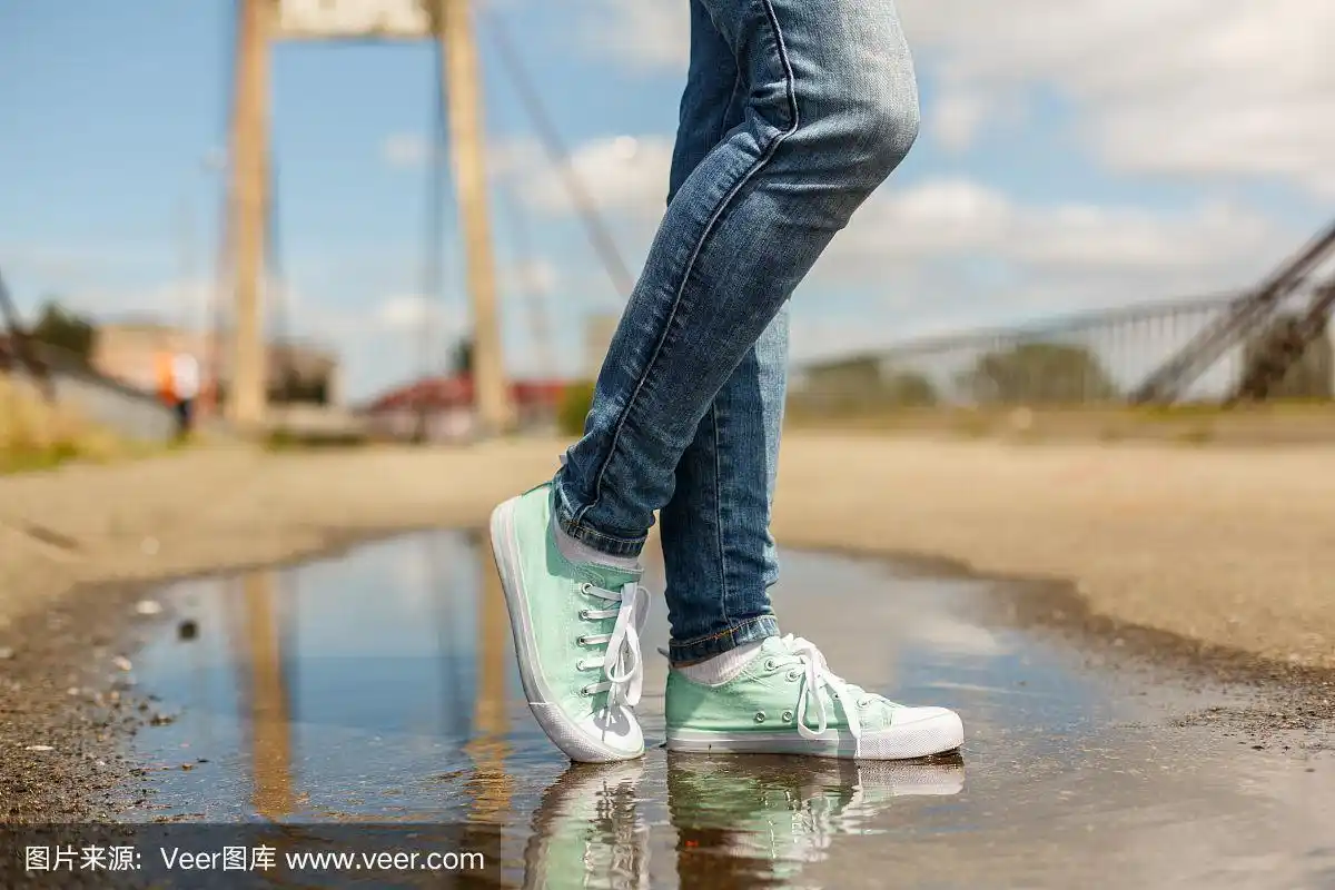 穿着运动鞋站在水坑里的女人