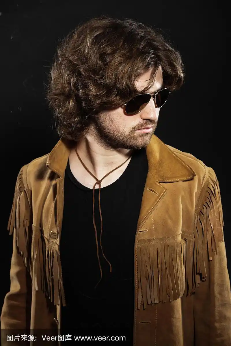 有着棕色长发和胡须的酷摇滚音乐家.