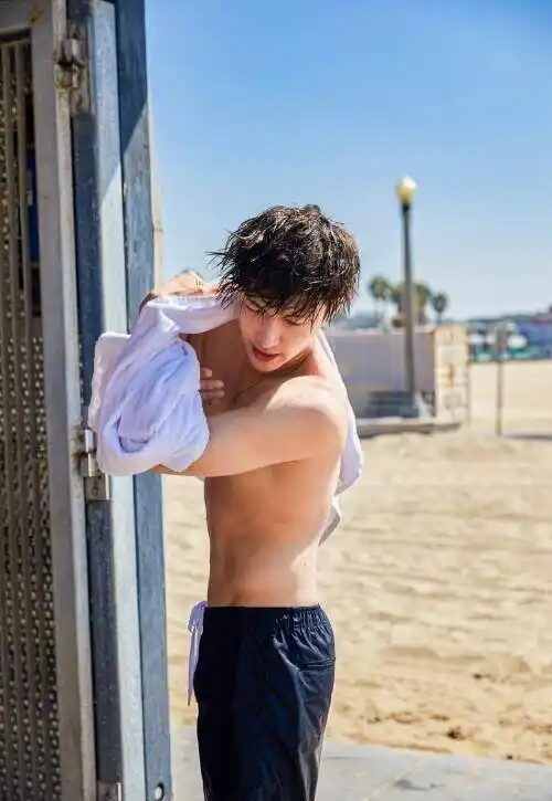 照片中,张艺兴只穿着泳裤,赤裸上身露出腹肌,抱着冲浪板在海浪间穿行