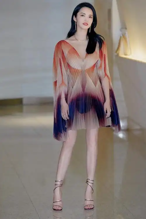 照片中姚晨身穿七彩渐变百褶裙,脚上搭配一双金色的绑带高跟凉鞋,极简