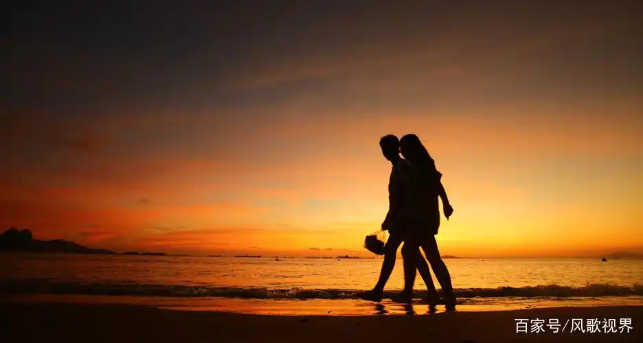 一情侣在海边夕阳中散步.