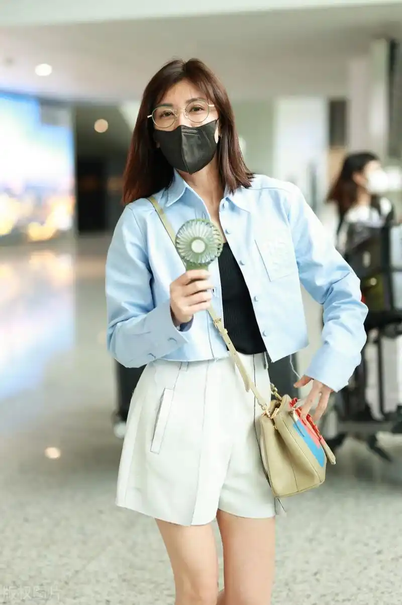 贾静雯机场街拍,蓝色衬衫外套搭配阔腿短裤,乐福鞋轻松自在!