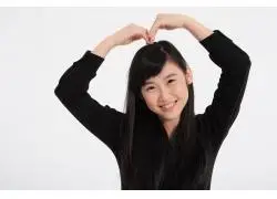 双手放在头顶做心形手势的开心女孩图片