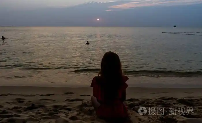 坐在海滩上,美丽的日落景色,瑜伽概念,在平静的海浪中观看大海