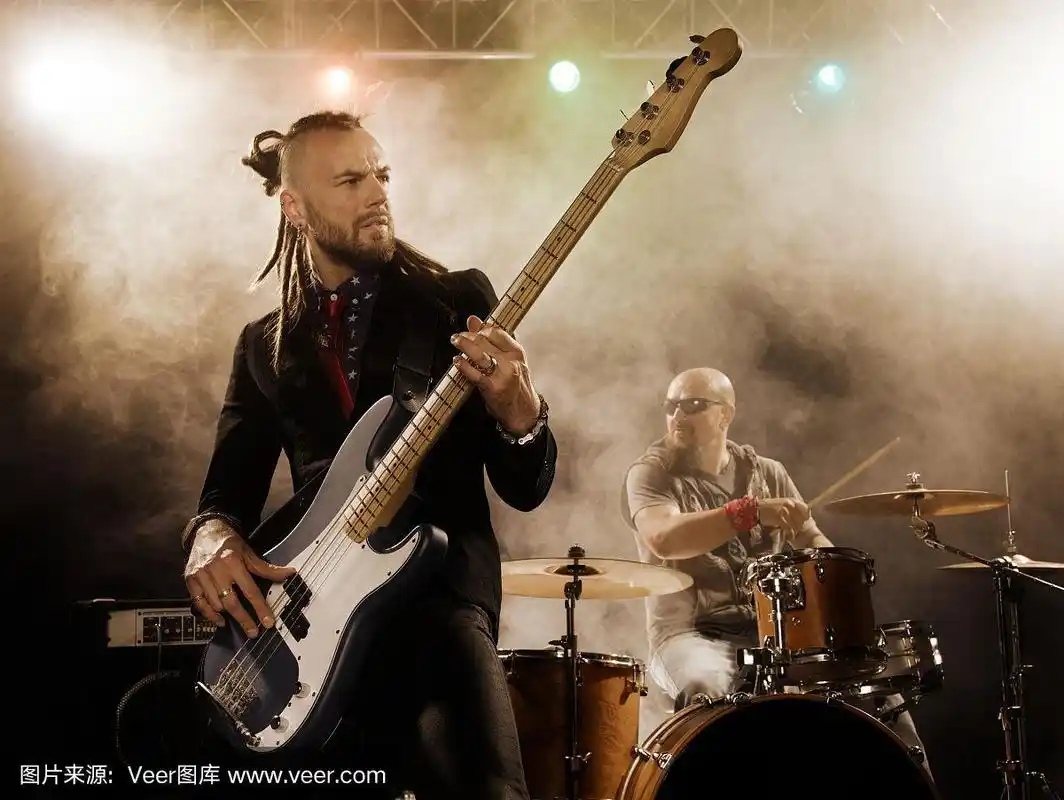 摇滚乐队在舞台上表演.贝斯手在前台.