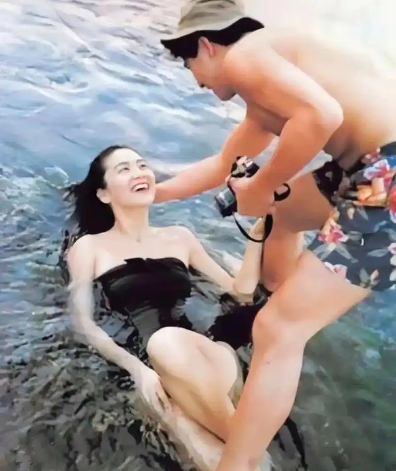 上世纪90年代的一张照片中,年轻的林青霞身穿泳衣,躺在海水中.