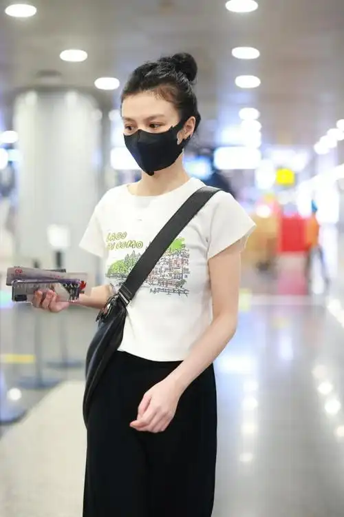 演员春夏黑白简约造型现身首都机场高扎丸子头露光洁白皙额头