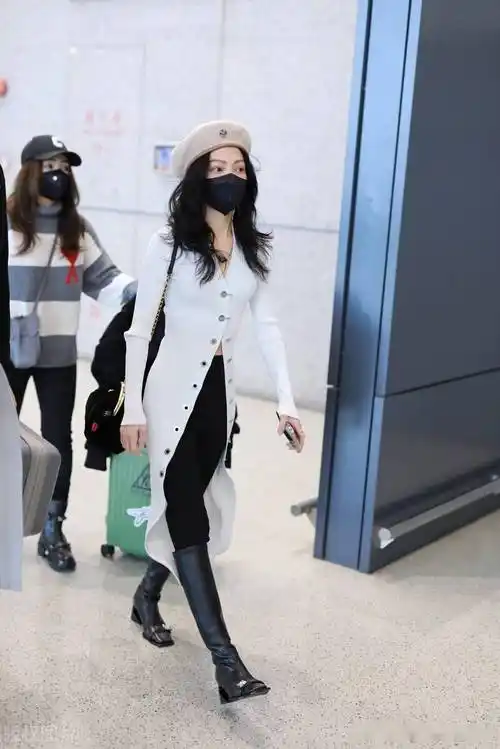 街拍:张韶涵一袭白色针织开衫衣搭长靴走路带风潇洒随性_机场_上海