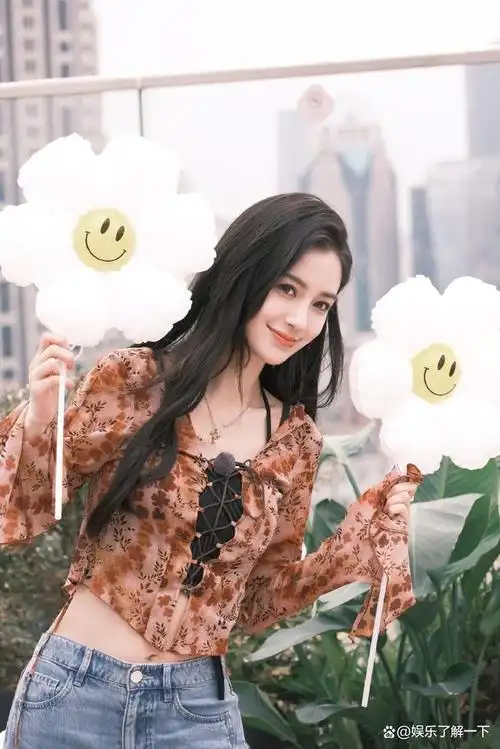照片中的angelababy手举着一个可爱的太阳花气球,笑容灿烂,散发出强大