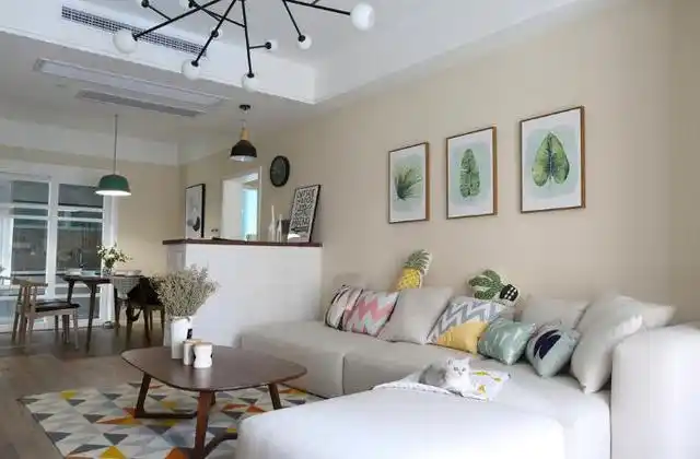 米黄色的墙面搭配清新的树叶挂画,米色的沙发是菠萝最喜欢的午睡地.