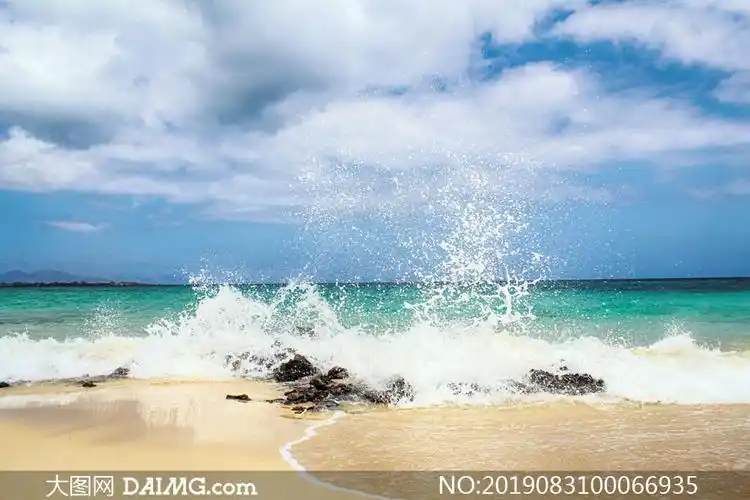 海边沙滩上溅起的浪花摄影图片