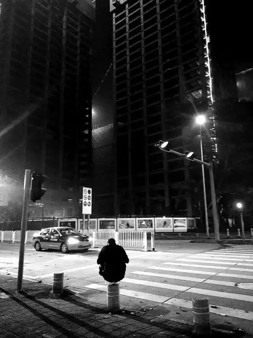 步行的路上,在十字路口遇到一个蹲在石墩上阅读的人