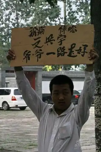 市民高举悼念标语新浪娱乐讯 文兴宇追悼会及遗体告别式于3日上午9时