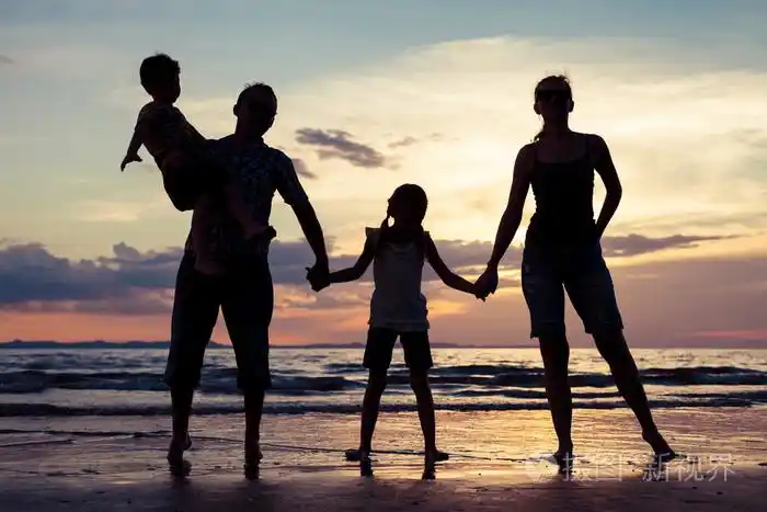 幸福的家庭的剪影在一元在沙滩上玩的人