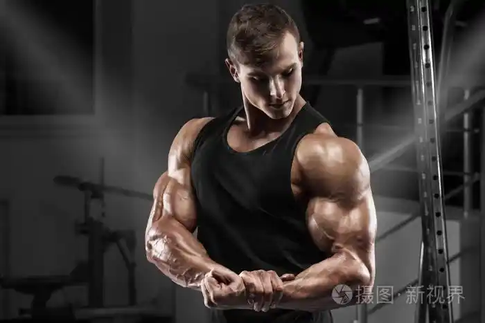 肌肉男在健身房锻炼.强壮的男性显示肌肉肱二头肌