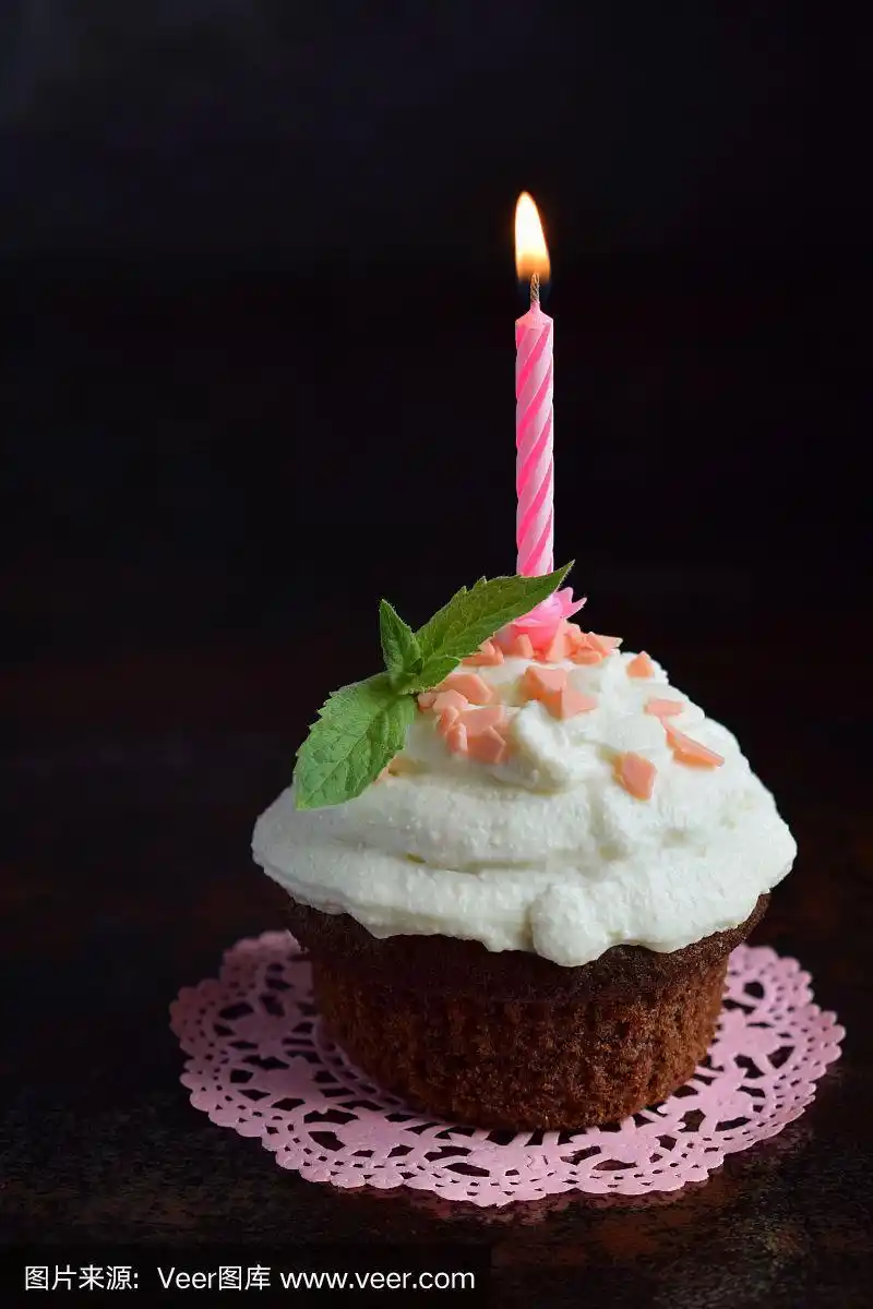 巧克力蛋糕加香草奶油和蜡烛.生日快乐.黑暗的照片