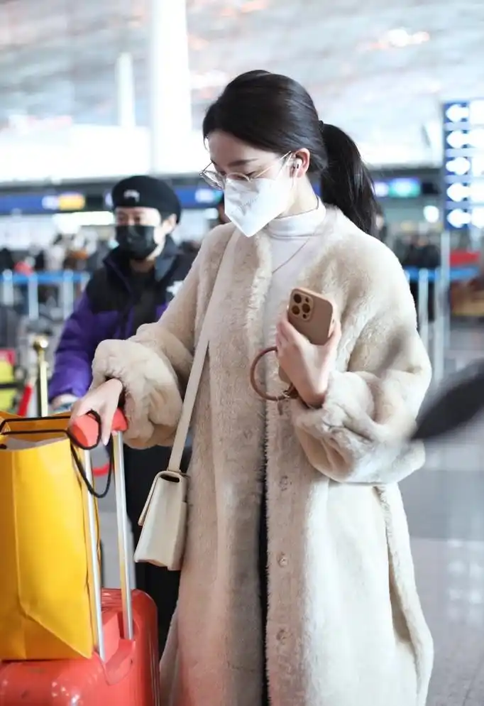 28岁陈瑶穿白色毛绒大衣走机场,扎低马尾发型,温柔又恬静!