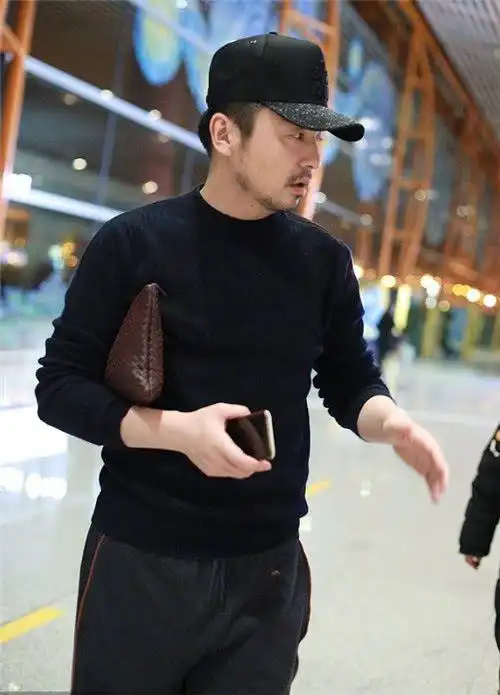 雷佳音现身机场手包夹出了煤老板范儿一个细节暴露壕属性