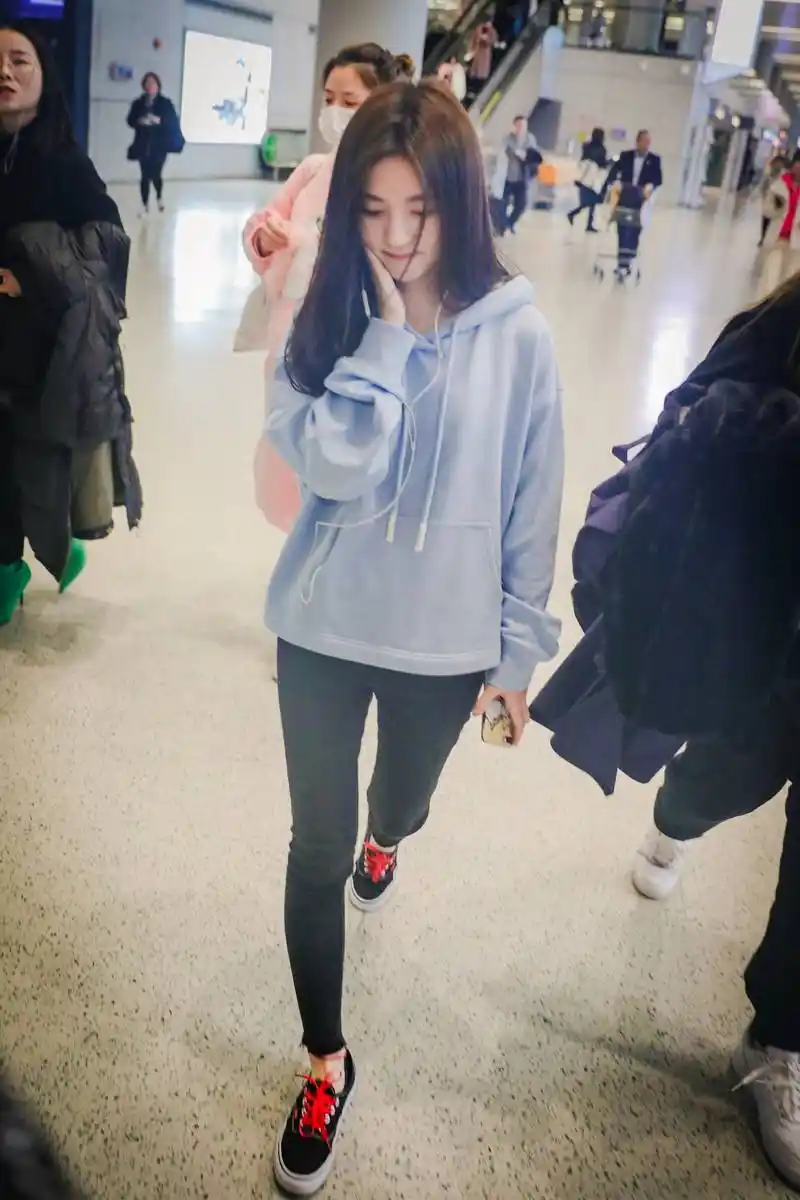 鞠婧祎穿蓝色连帽卫衣现身机场皮肤白皙