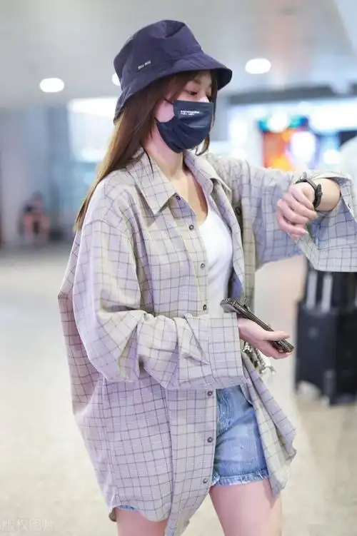 程潇现身北京机场身穿白色吊带上衣牛仔短裤方格小褂超女范十足