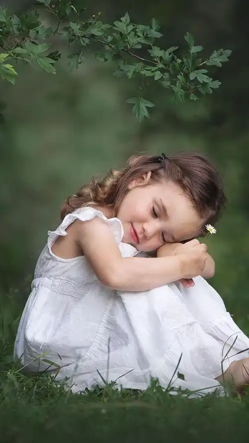 可爱的小女孩坐在地面上,白色的裙子,自然 iphone 壁纸