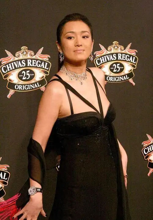 巩俐身材虽然丰满,可是穿抹胸裙仍担心挂不住,用绑带连接挺高明