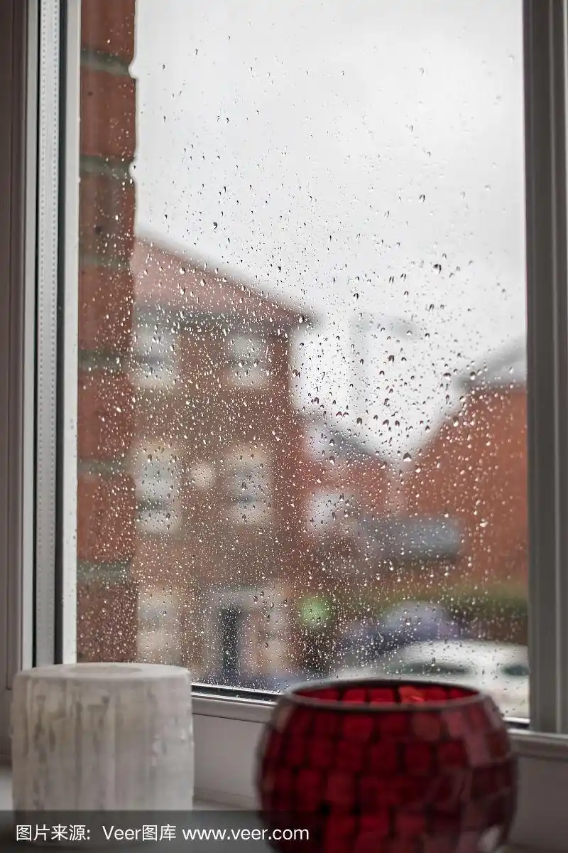 透过雨水滴在房子窗户上的景色.