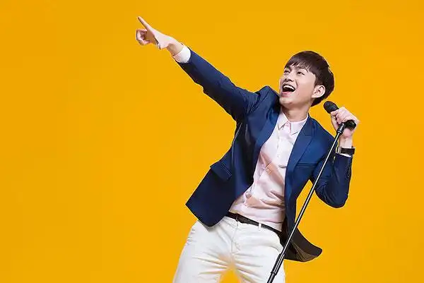 快乐男生拿着麦克风唱歌