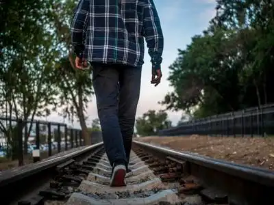 孤独的人在铁轨上走得很远的后面一个人在农村的路上走得很远.