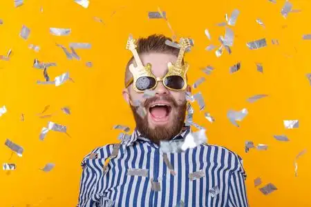 一个疯狂的年轻的,积极的,有胡子的时髦男人在黄色背景的飞行科菲蒂